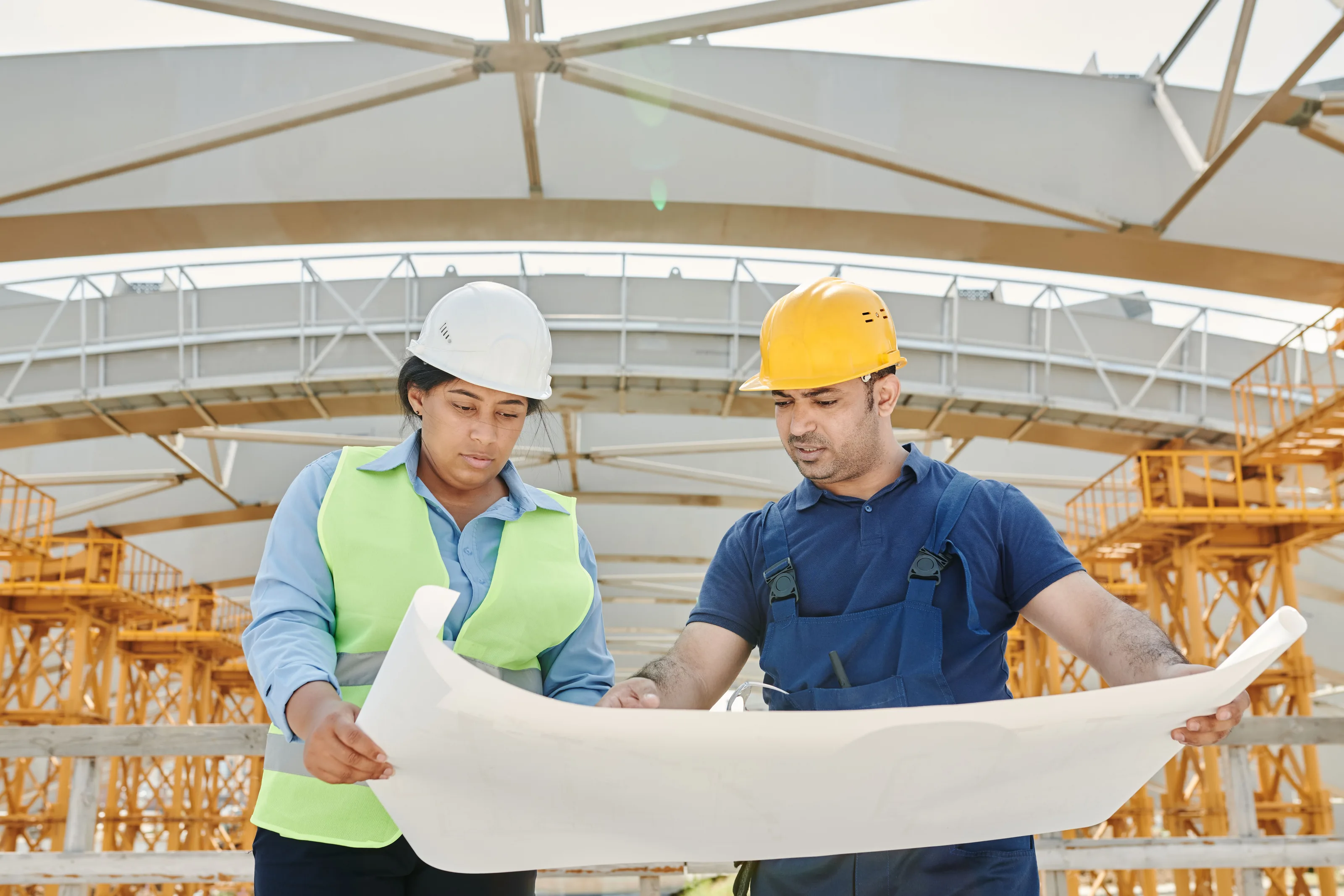 Dos ingenieros revisan planos en una obra